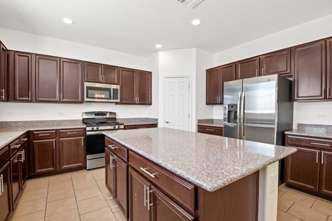 A kitchen with brown cabinets and a granite countertop.