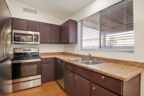 A kitchen with brown cabinets and a granite countertop.