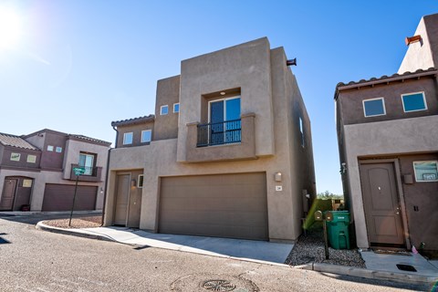 A modern house with a garage door and a window with a blue frame.