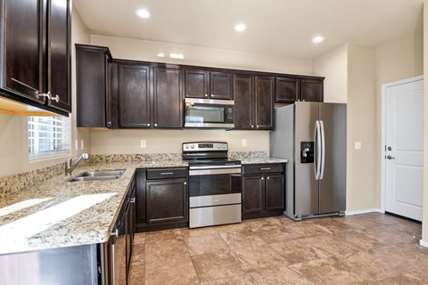 A kitchen with brown cabinets and a refrigerator.