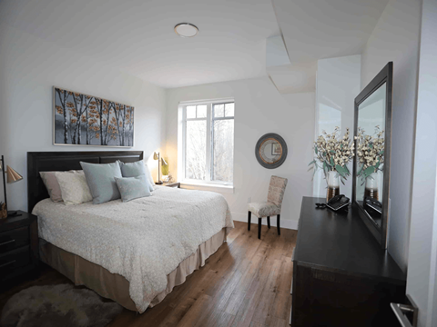 a bedroom with a bed and a dresser and a window