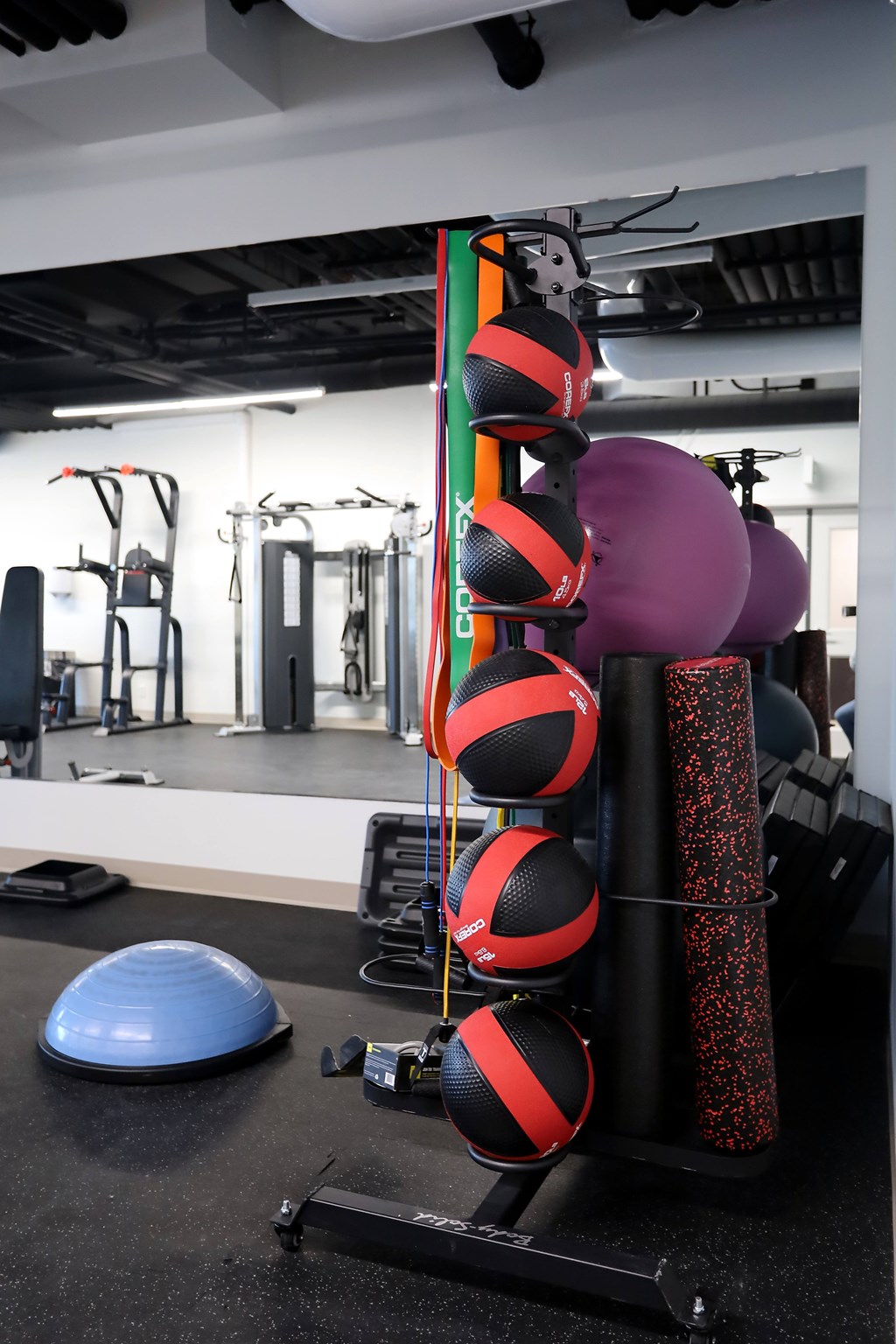 A gym with a variety of equipment including a blue balance ball.