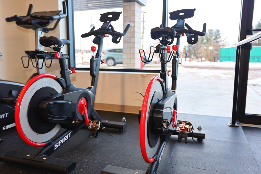 Two stationary bikes are parked next to each other.