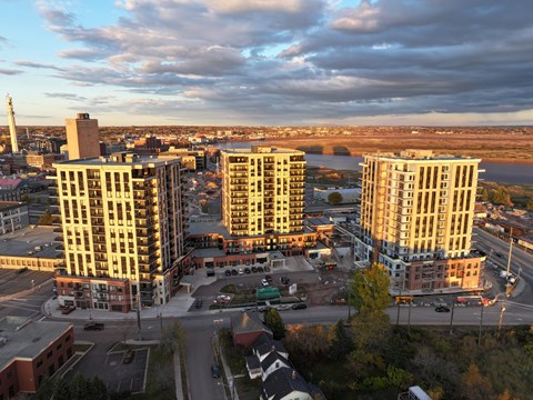 A cityscape with buildings and a cloudy sky.