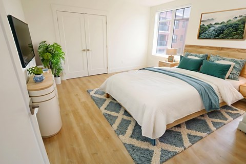 A bedroom with a large bed and a TV on the side.