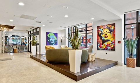 a living room with a couch and paintings on the wall