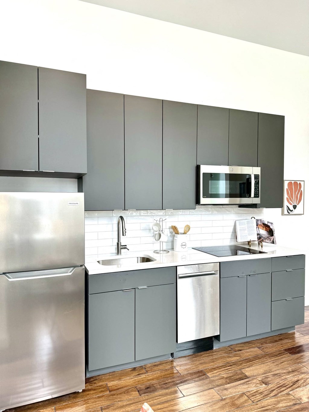 a kitchen with stainless steel appliances and gray cabinets