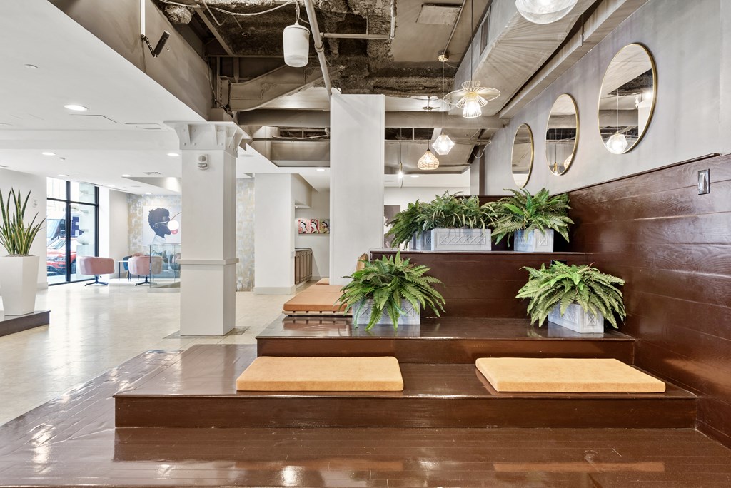 a large lobby with wooden benches and potted plants