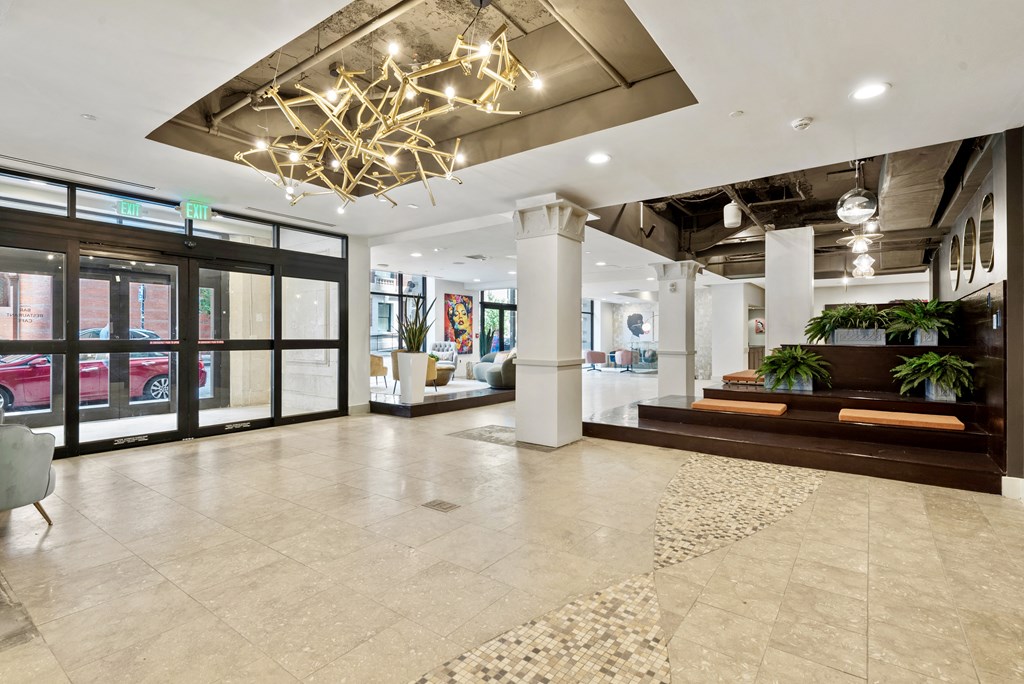 a lobby with a chandelier and glass doors