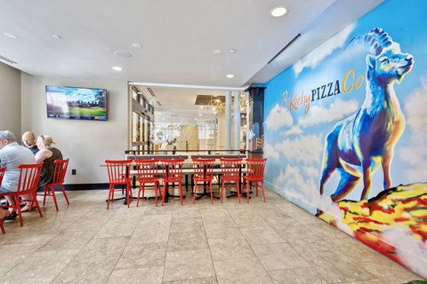 a dining room with red chairs and a mural of a blue horse