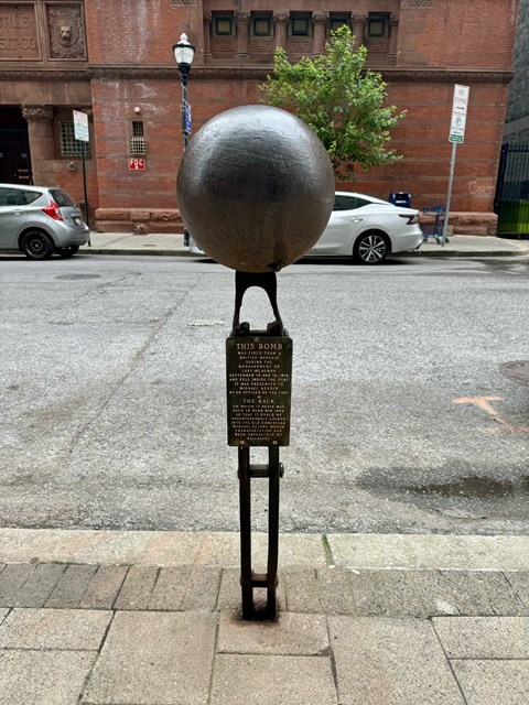 a statue of a globe on a street