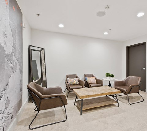 a living room with four chairs and a wooden table