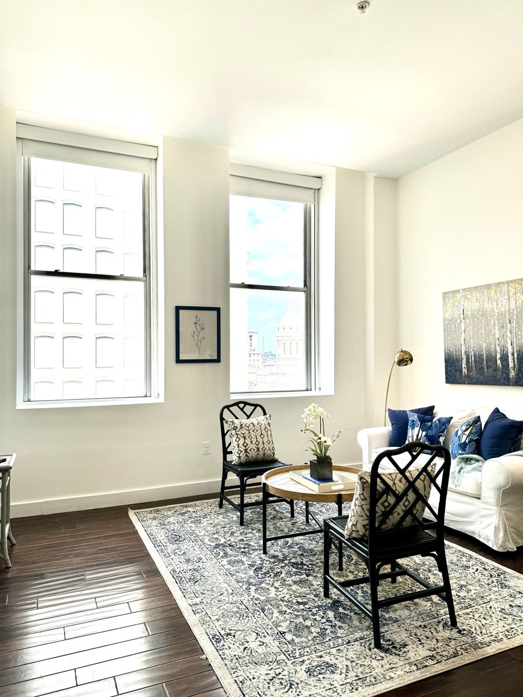 a living room with a couch and two chairs and a rug