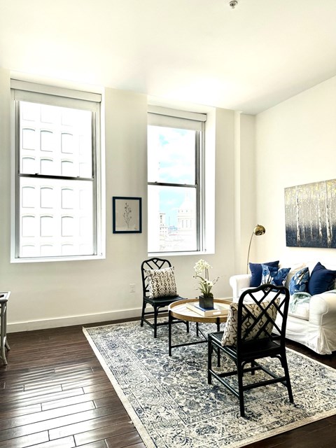 a living room with a couch and two chairs and a rug