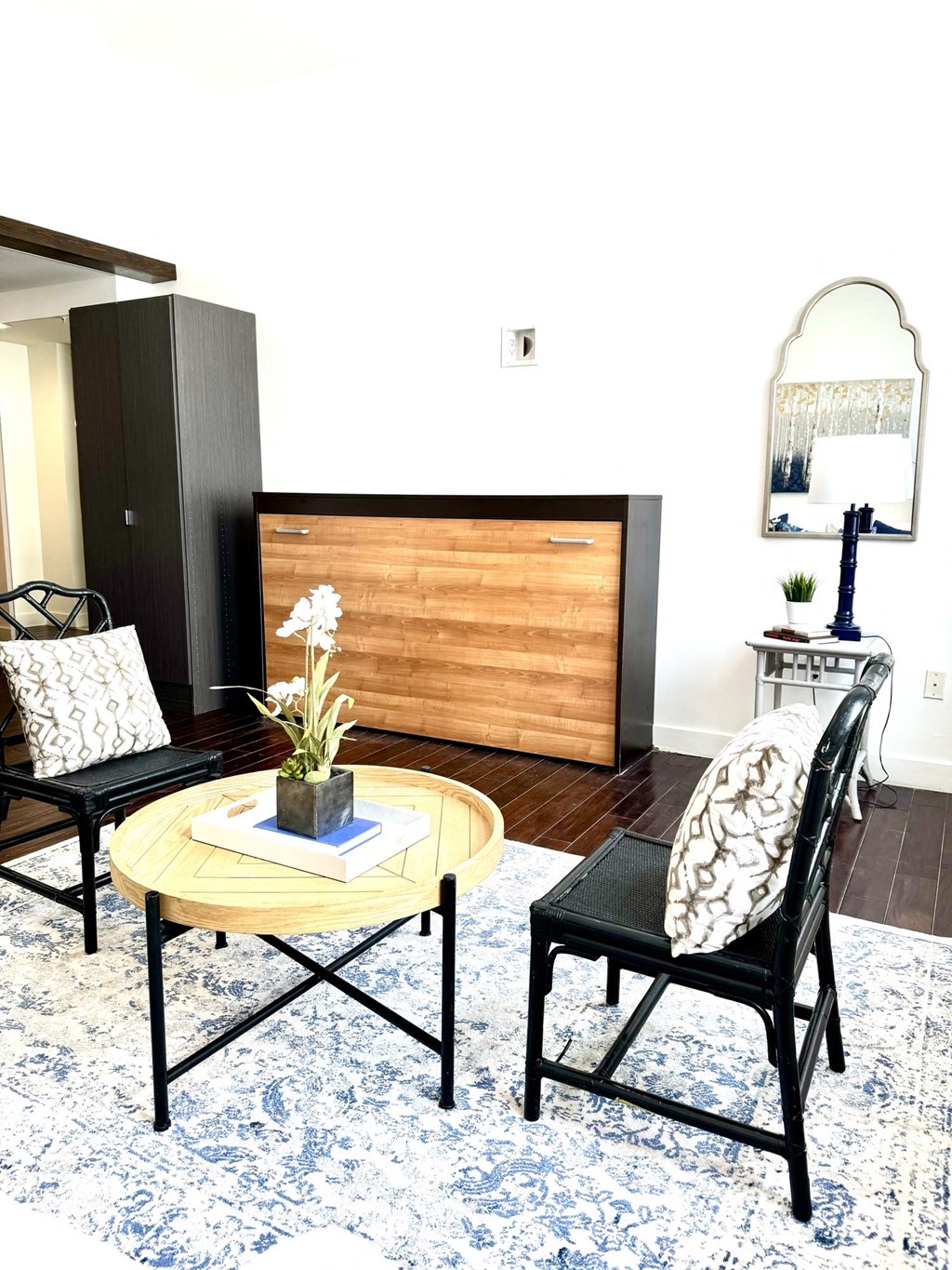 a living room with a table and chairs and a mirror