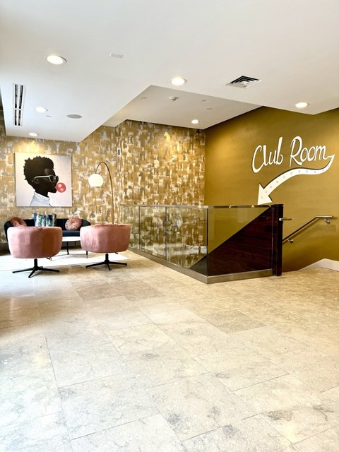the lobby of a club room with a reception desk and chairs