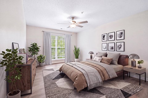 A bedroom with a large bed, a ceiling fan, and a rug on the floor.