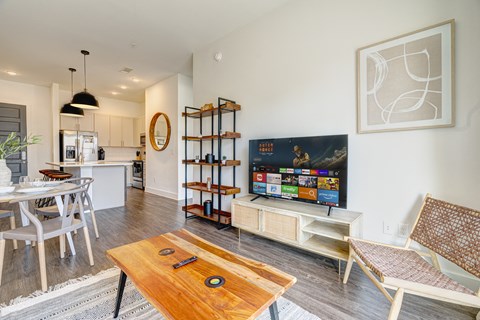 A modern living room with a wooden coffee table in the center.