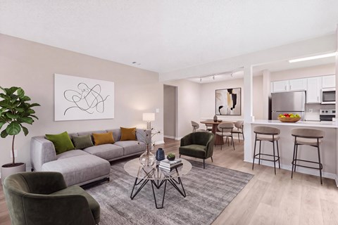 A modern living room with a grey sofa, green armchair, and a coffee table with a lamp on it.