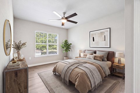 A bedroom with a large bed and a ceiling fan.