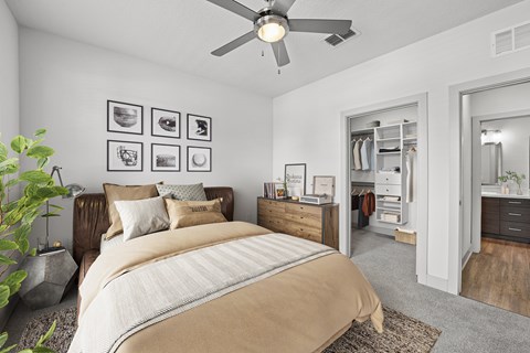 A bedroom with a large bed and a ceiling fan.