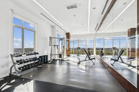 A gym with a view of the sky through the windows.
