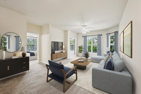 A living room with a grey couch, a blue chair, a wooden coffee table, and a large mirror on the wall.