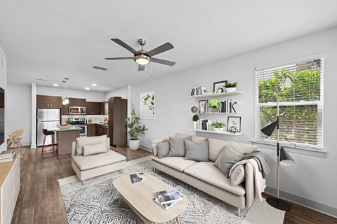 A living room with a couch, a coffee table, and a ceiling fan.