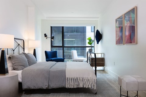 A bedroom with a large bed and a chair.