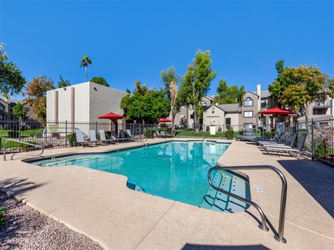 a swimming pool with a fence and a building in the background