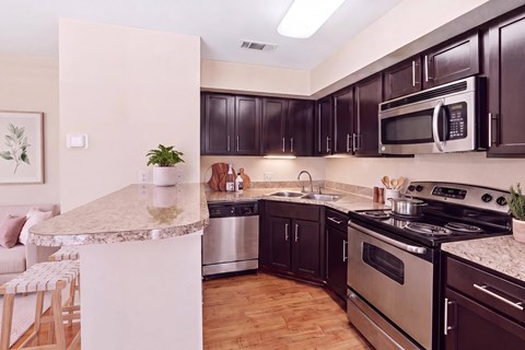 A kitchen with dark brown cabinets and stainless steel appliances.