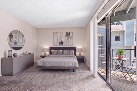 A bedroom with a large bed and a balcony.