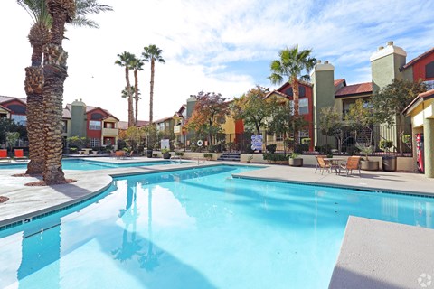 One of 4 swimming pools with palm trees and sun deck.