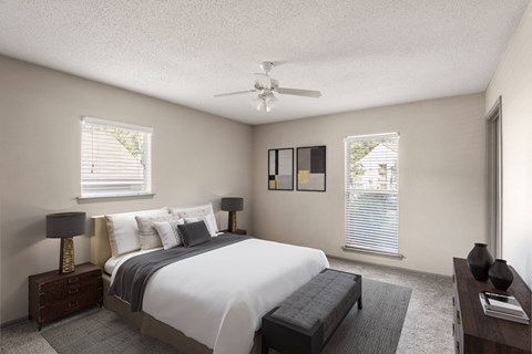 A bedroom with a large bed and a ceiling fan.