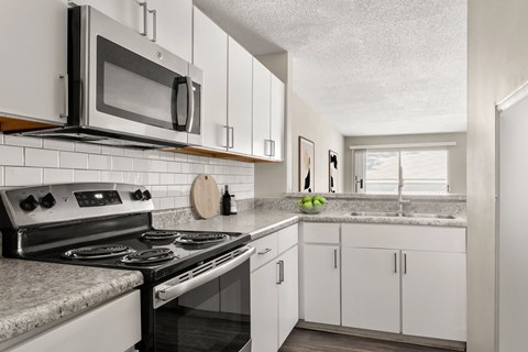 A kitchen with a stove, microwave, and refrigerator.