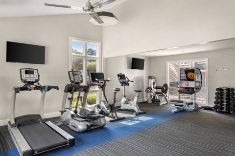 a gym with treadmills and other exercise equipment and a window