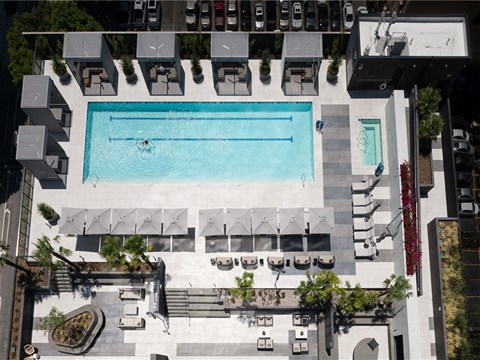 A large swimming pool surrounded by lounge chairs and umbrellas.