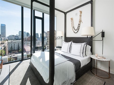 a bedroom with a bed and a view of the city