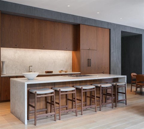 A modern kitchen with a white countertop and wooden cabinets.