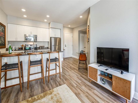 a kitchen with a bar and a table with chairs