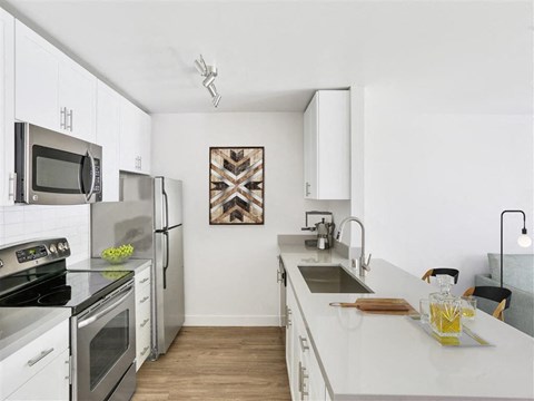 a kitchen with white cabinets and stainless steel appliances