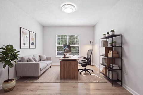 A room with a desk, a couch, a chair, a potted plant, and a bookshelf.