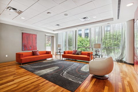 A living room with a red couch and a white chair.