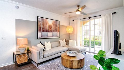 A living room with a white couch, a coffee table, and a painting on the wall.