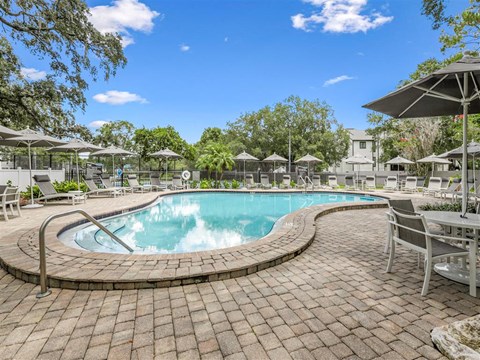 a swimming pool with umbrellas and chairs around it