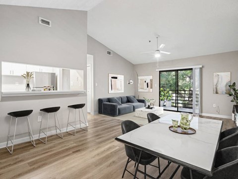 A modern dining room with a white table and black chairs.