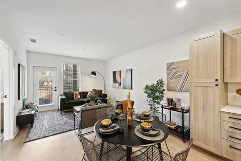 a living room and dining room with a table and chairs