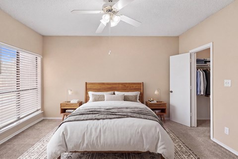A bedroom with a large bed and a ceiling fan.