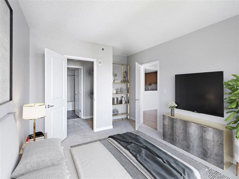 A modern living room with a grey carpet and a black television.