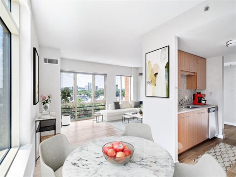 A modern kitchen with a marble table and a bowl of fruit on it.